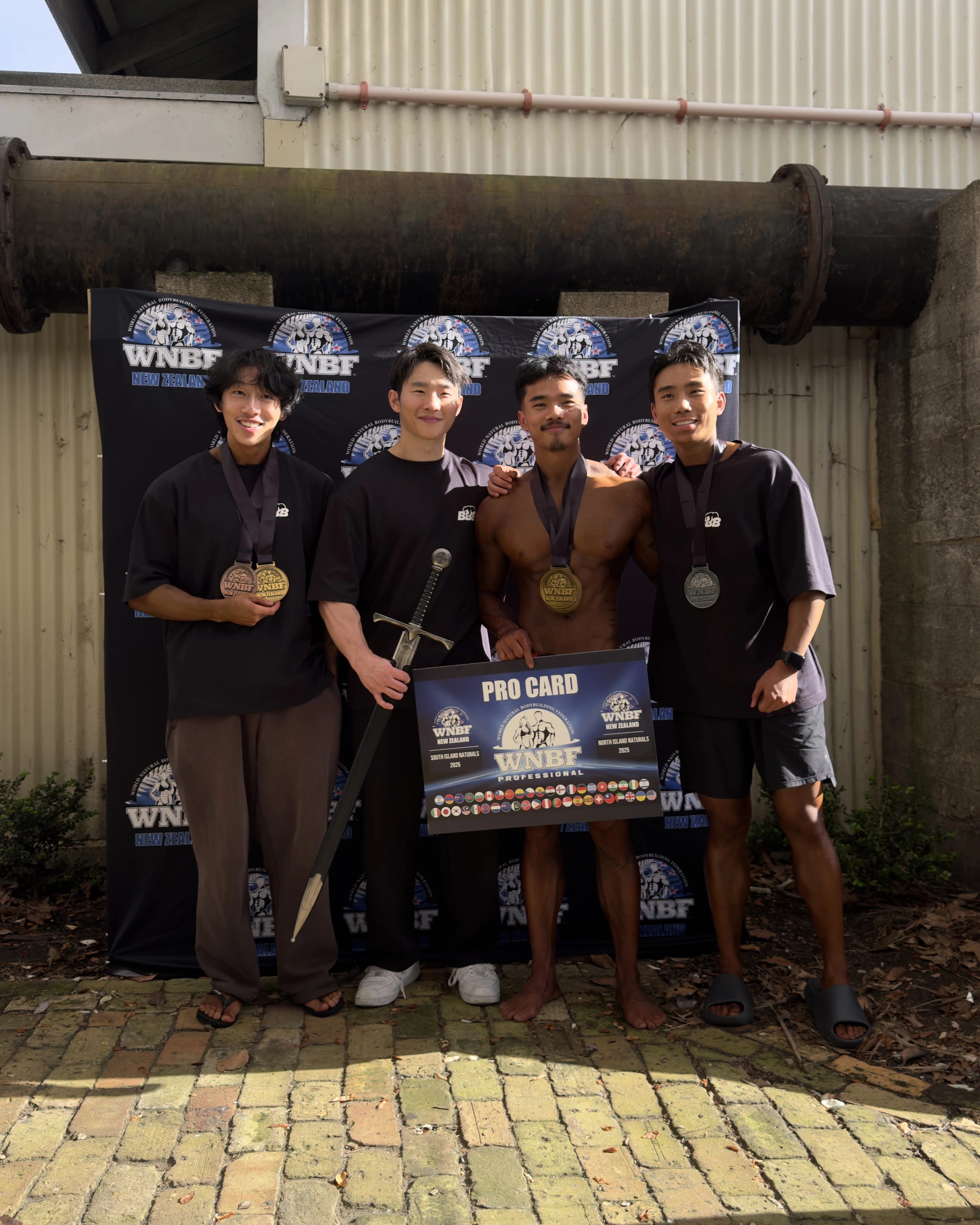 Four members of the BBB crew celebrating together with competition medals and awards.