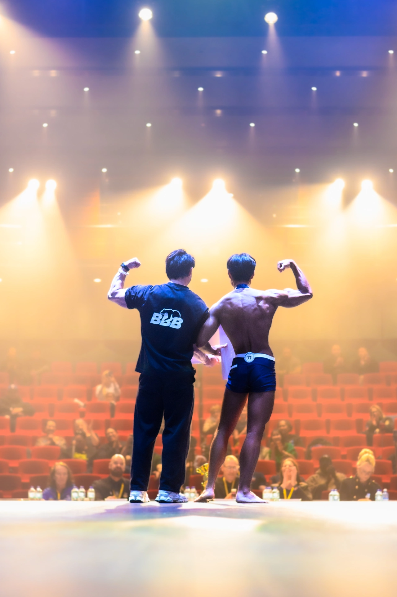 Boxi and a competitor posing side by side on a competition stage.